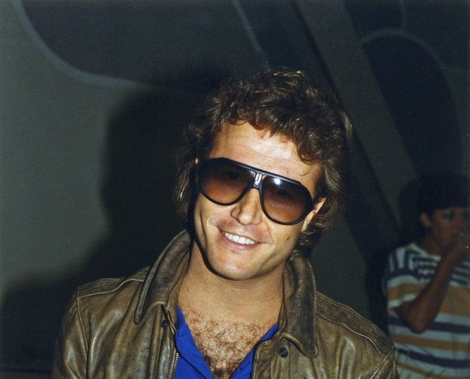 Andy Gibb attending a party and holding a cup of punch
