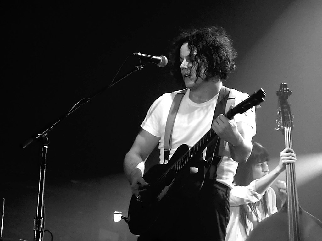 Grayscale Portrait Photo of  Jack White performing on stage
