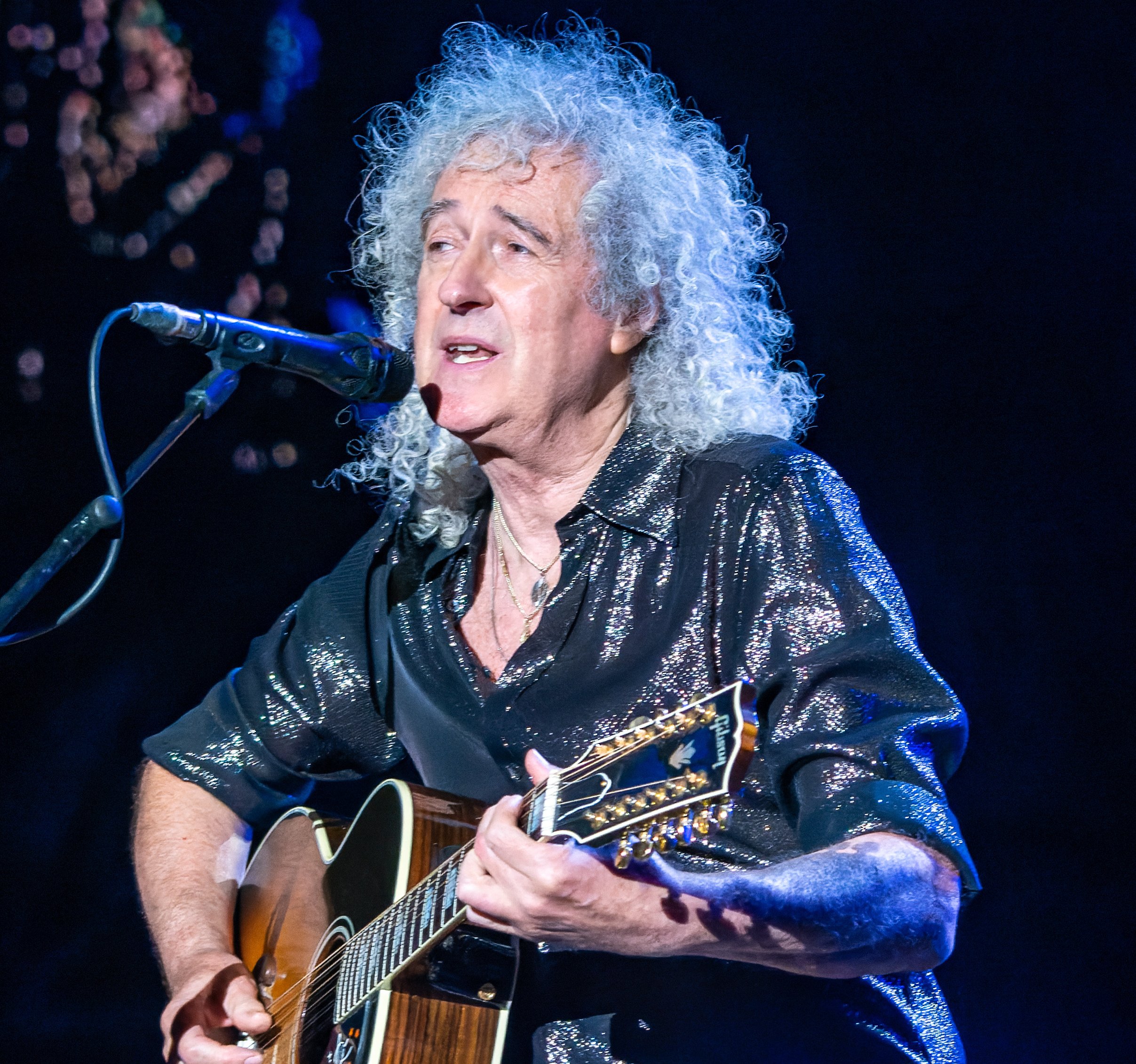 Portrait Photo of Brian May performing on stage.