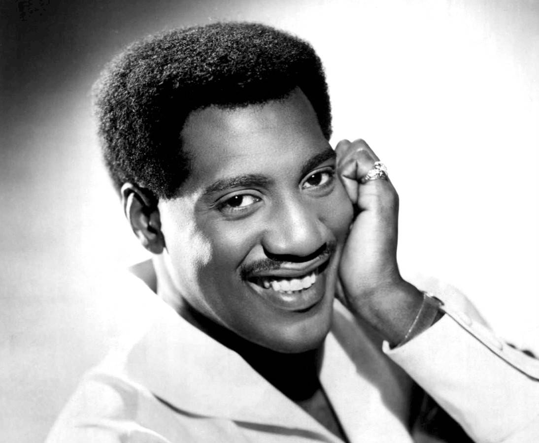 Grayscale Portrait Photo of singer Otis Redding in a white suit smiling