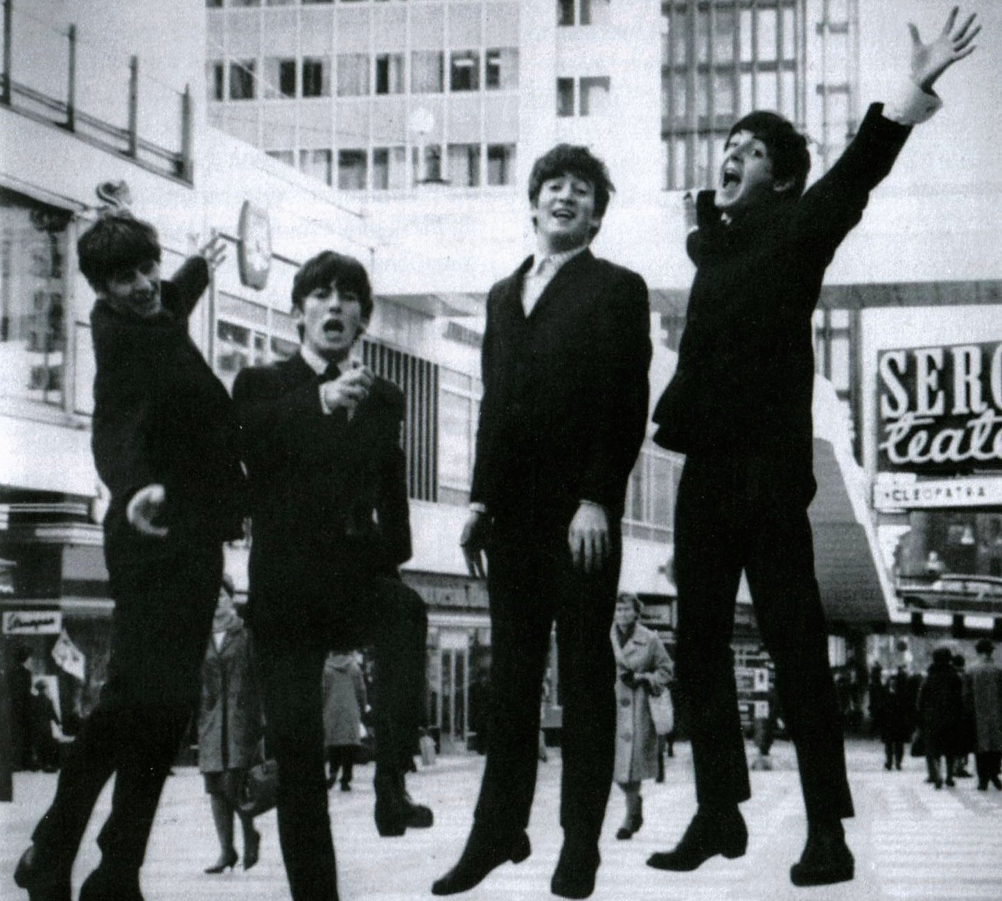 Grayscale Portrait Photo of The Beatles Jumping in the air