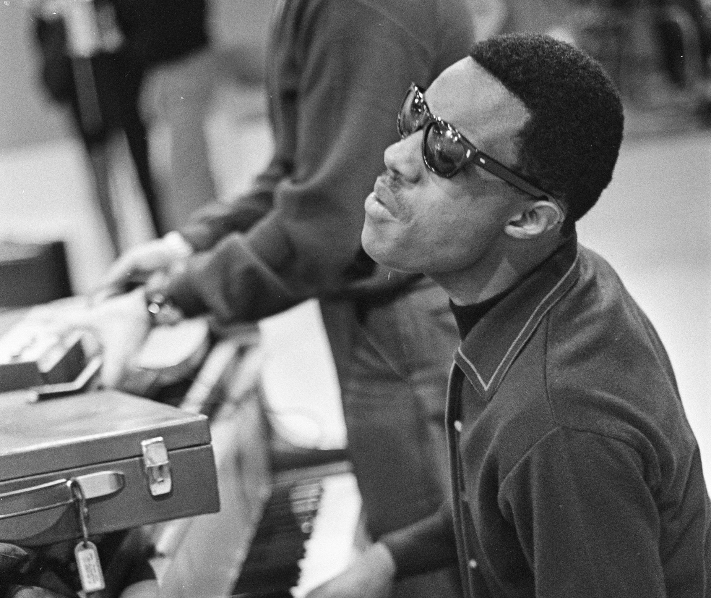 Grayscale Portrait Photo of Stevie Wonder performing on piano.