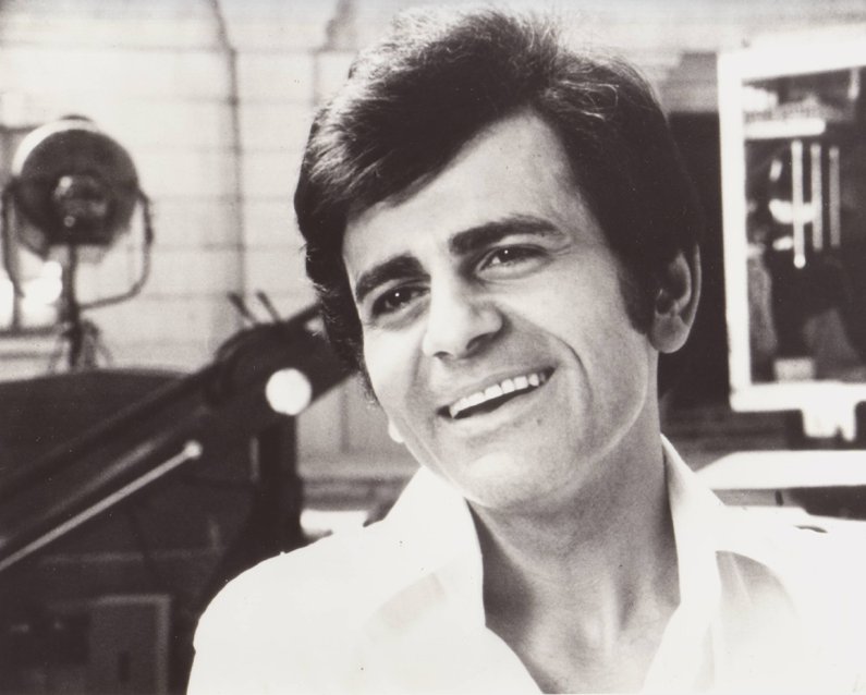 Grayscale Portrait Photo of Casey Kasem in a white shirt, smiling