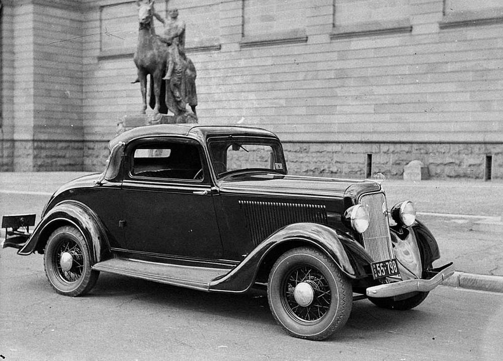 Grayscale Photo Plymouth coupe parked in front of a statue.