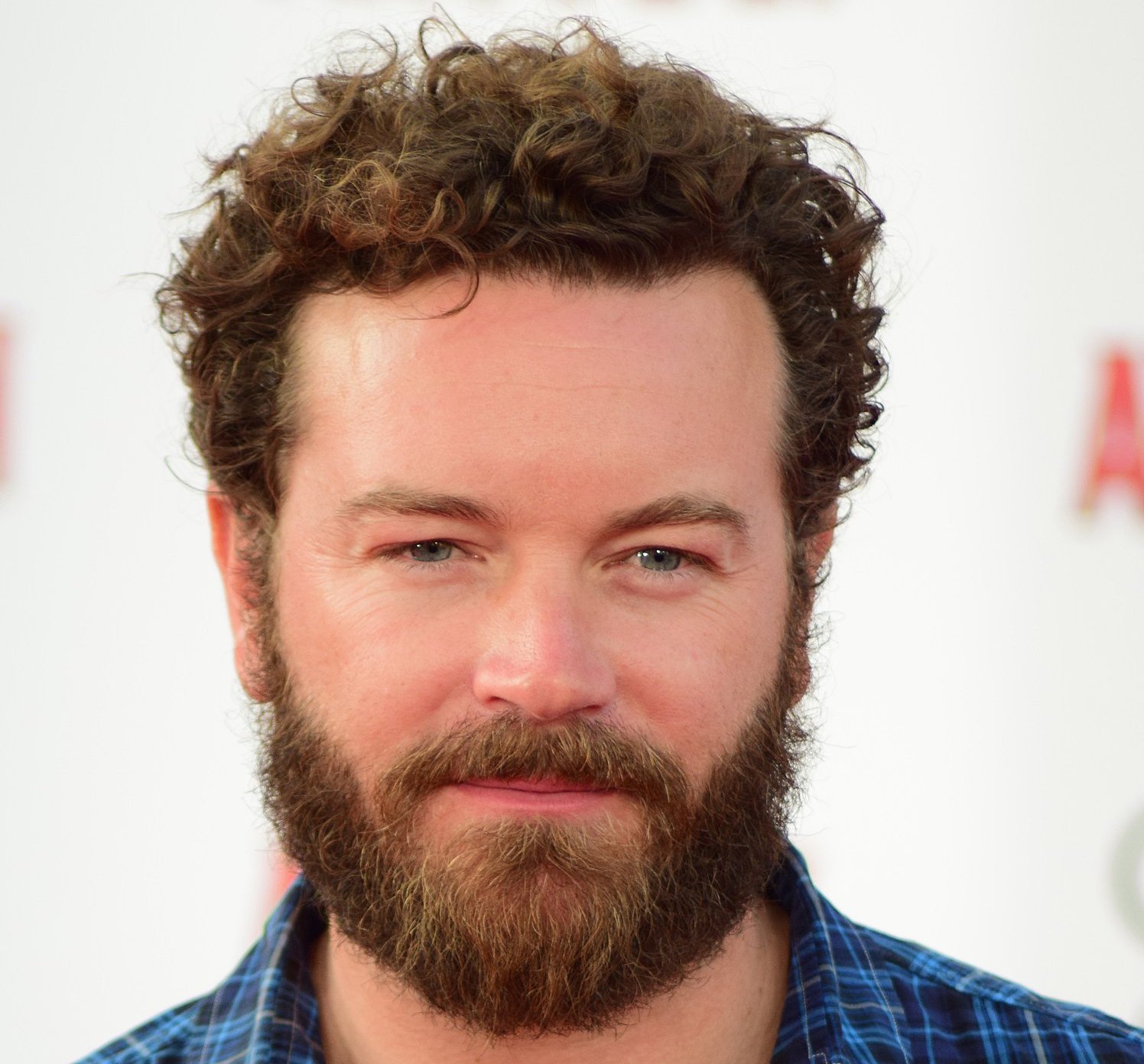 Portrait Photo of the actor Danny Masterson in a blue shirt, smiling