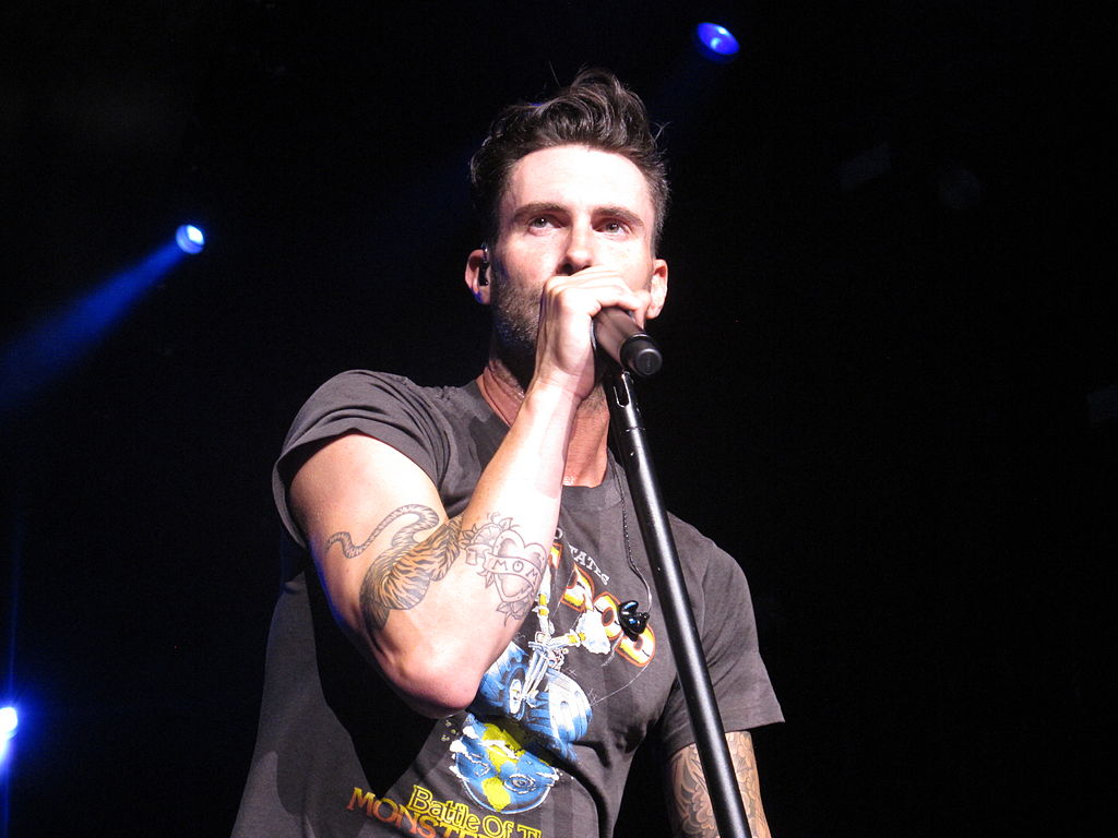 Portrait Photo of Adam Levine in a gray t-shirt performing on stage