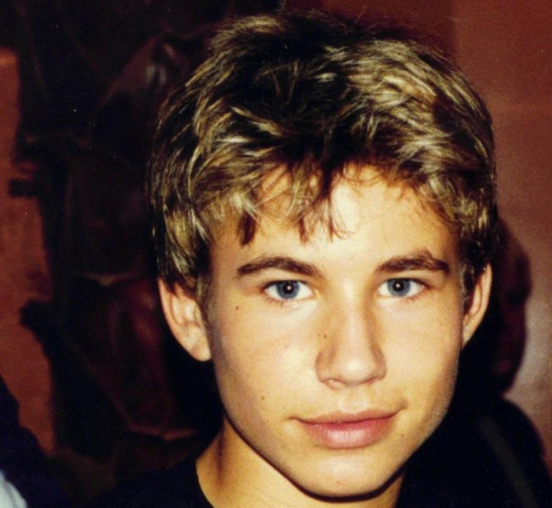 Portrait Photo of the Actor Jonathan Taylor Thomas in a dark outfit