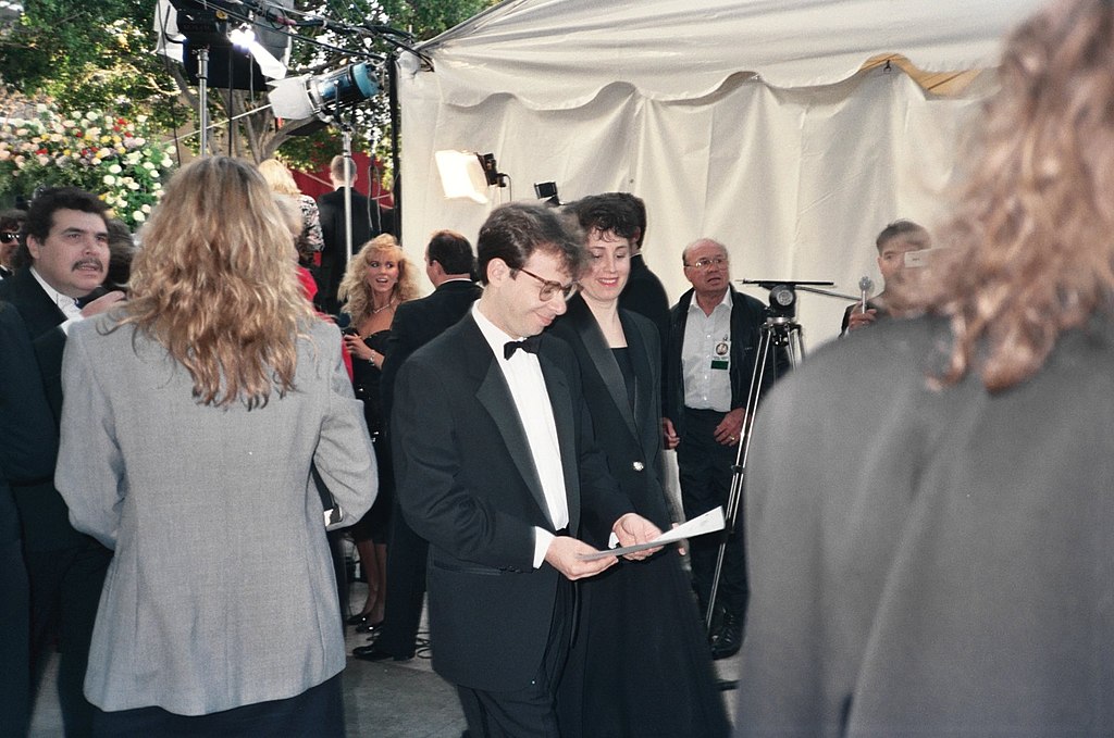 Portrait Photo of the actor Rick Moranis in a dark suit, smiling