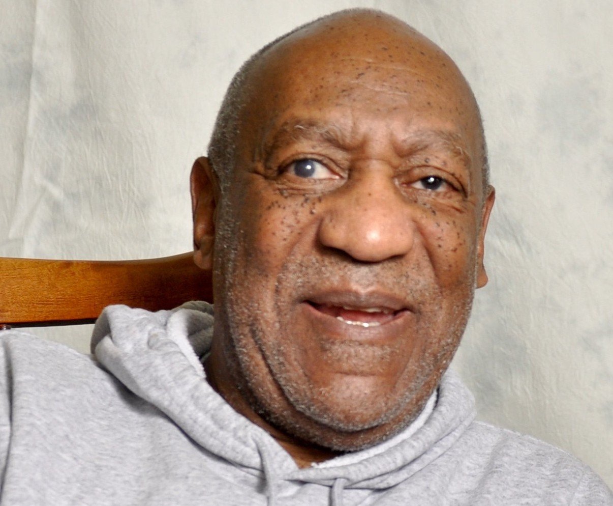 Portrait Photo of Bill Cosby in a gray outfit, smiling
