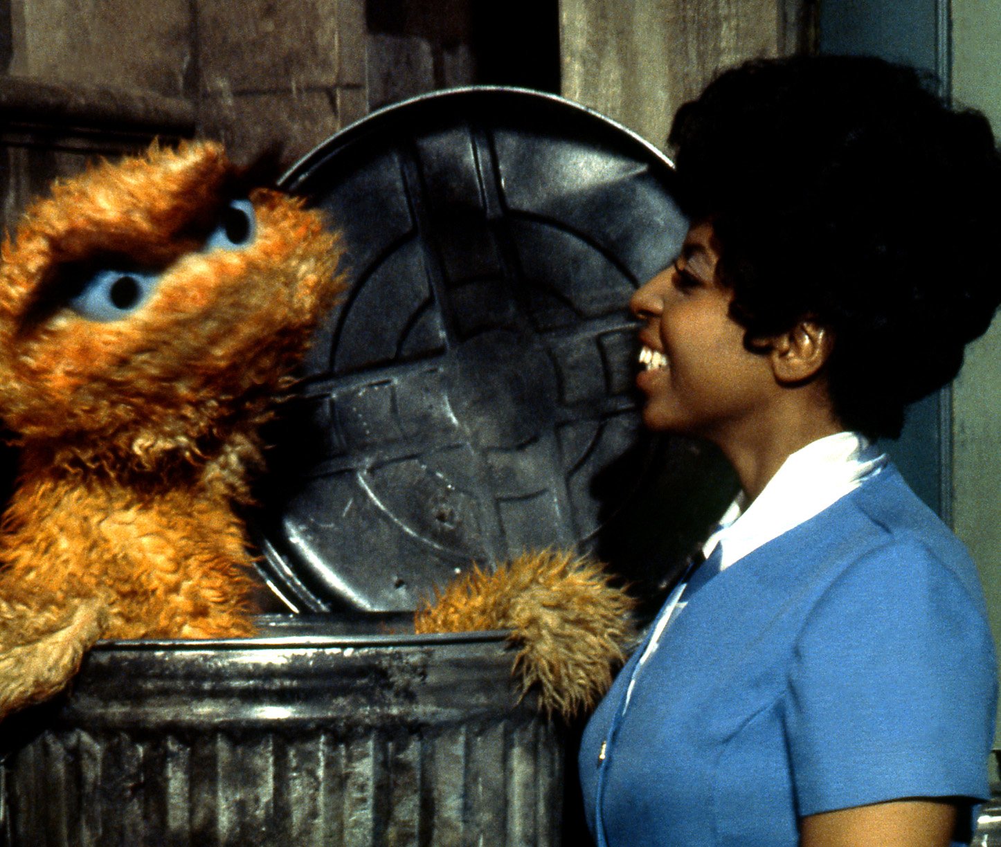 Muppet Oscar the Grouch (L) and actress Loretta Long as the character Susan Robinson (R)