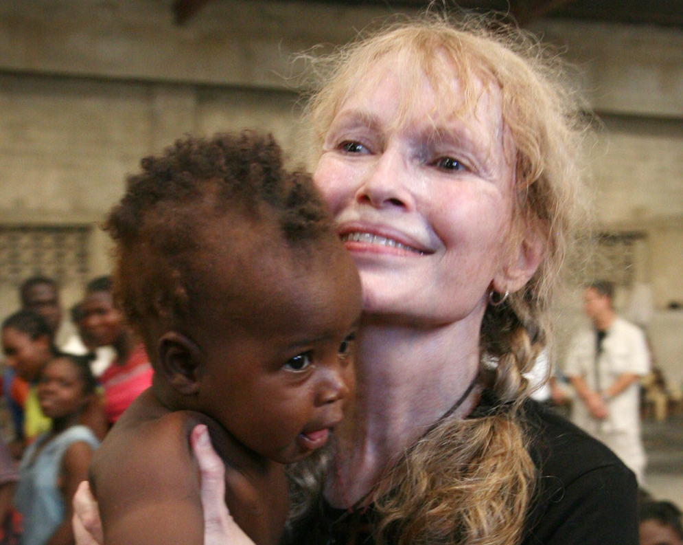 UNICEF Goodwill Ambassador Mia Farrow holds a baby at a warehouse - 2008