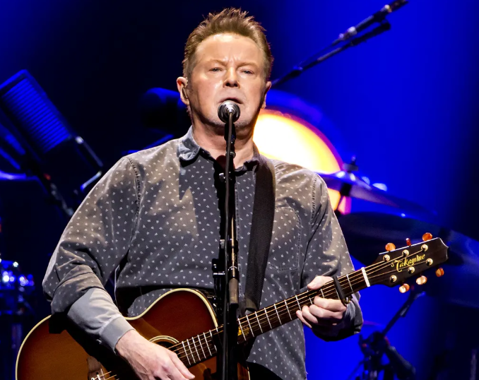Photo of Don Henley in gray shirt performing on stage