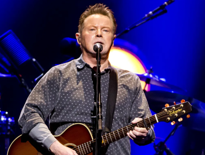 Don Henley performing on stage with his guitar