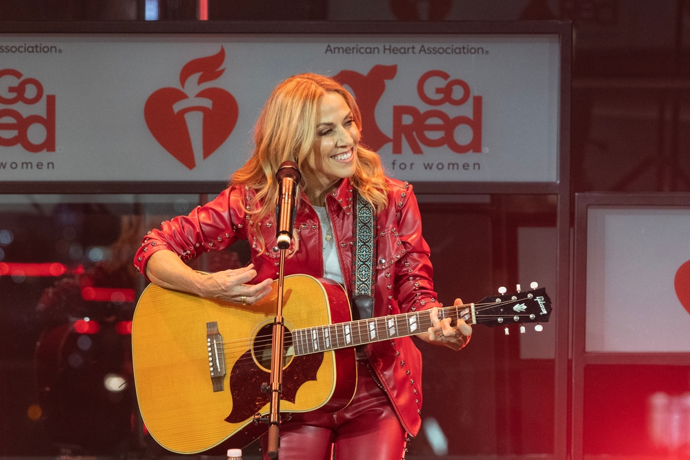 Sheryl Crow performs on stage wearing dress by Michael Ngo