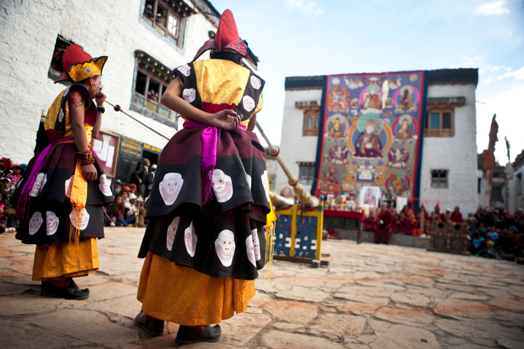 Elaborately dressed monks play Dungchen (Tibetan long horns) during the Tiji Festival in Lo Manthang, Upper Mustang