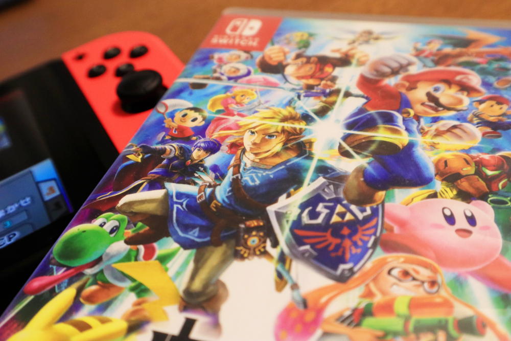 Nintendo Switch and Super Smash Bros Ultimate game on Wooden Table.