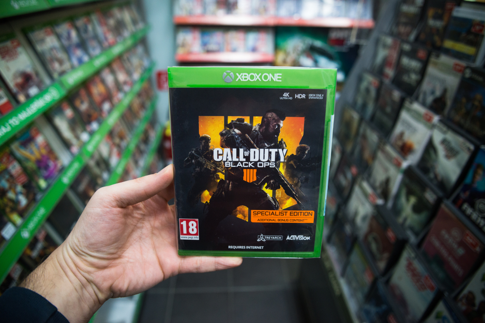 Man holding Call of Duty Black Ops 4 videogame on Microsoft XBOX One console in store