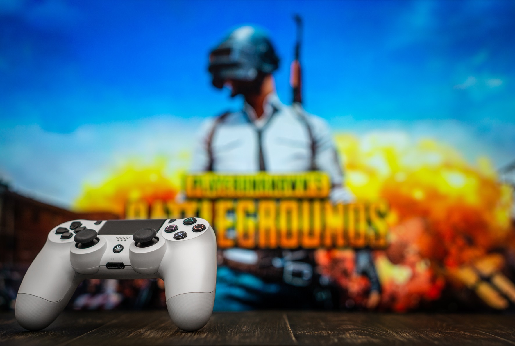 White playstation 4 gamepad on the background of the game PUBG.
