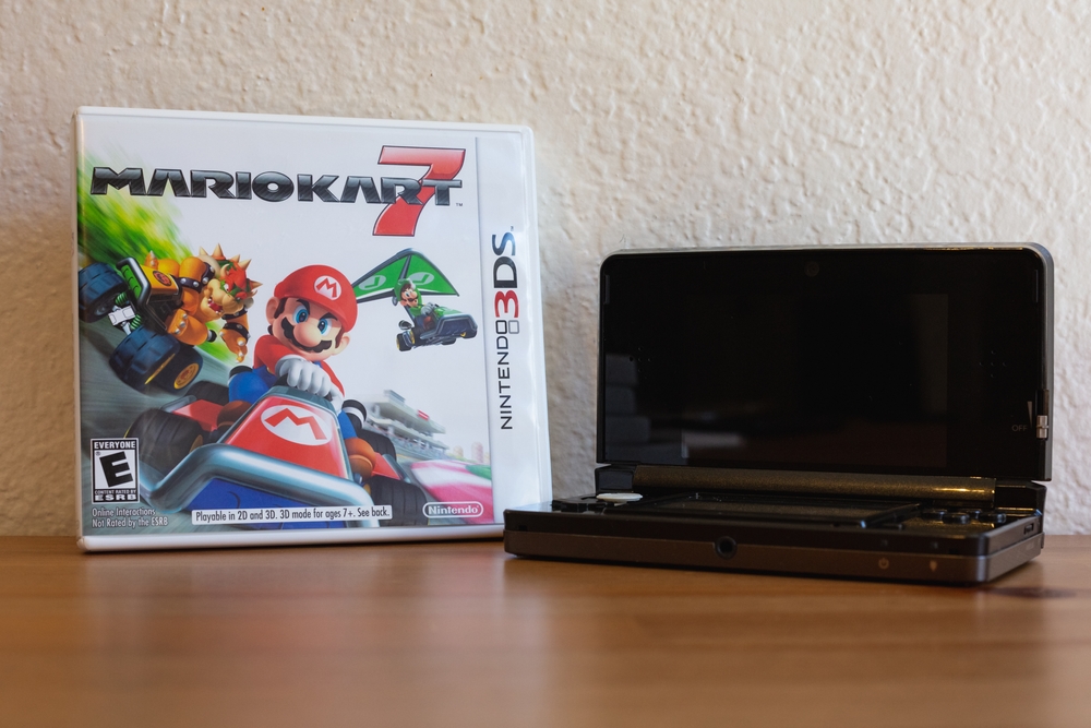 Mario Kart 7 and a Nintendo 3DS on a table in a home.