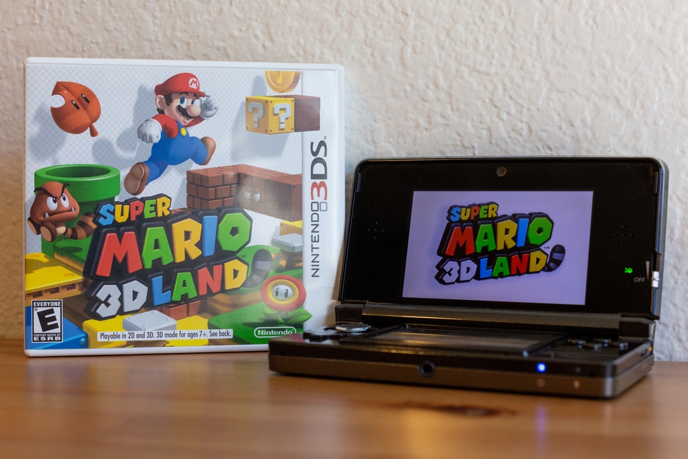 Super Mario 3D Land with a Nintendo 3DS on a table in a home.