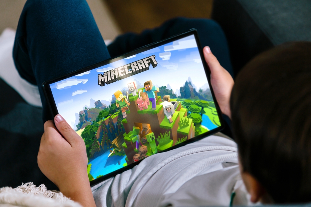 Little boy playing Minecraft game on a tablet.