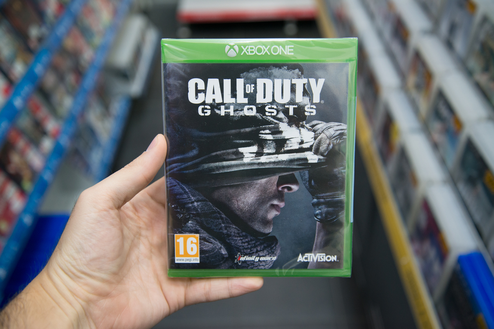 Man holding Call of Duty Ghosts videogame on Microsoft XBOX One console in store