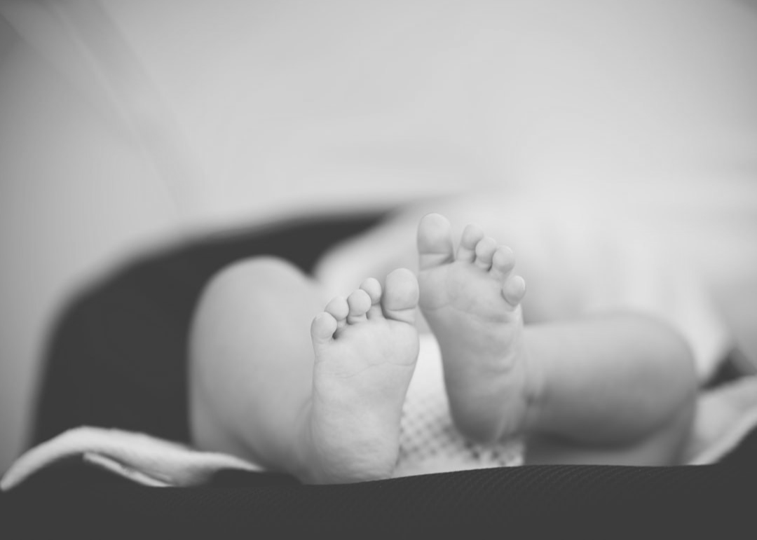 shallow focus photography of baby wearing white diaper lying