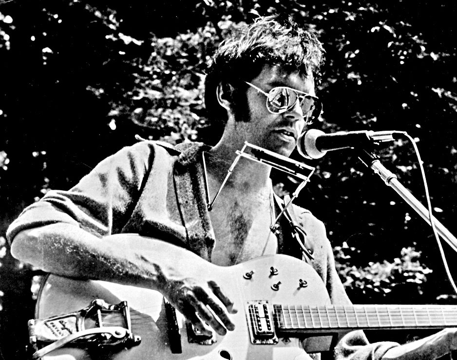 Grayscale Portrait Photo of Neil Young Performing on stage