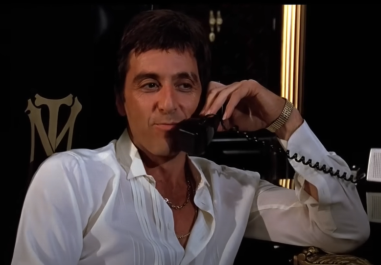 Al Pacino as Tony Montana in Scarface (1983), in white shirt speaking on the phone