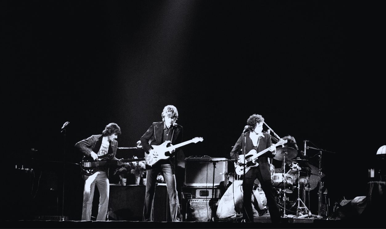 Gettyimages - 638561510, Bob Dylan with The Band 1974: Musician Bob Dylan (far right) plays with members of The Band, Rick Danko (1943-1999) on bass, Robbie Robertson on guitar and Levon Helm (1940-2012) on drums during a concert circa 1974.
