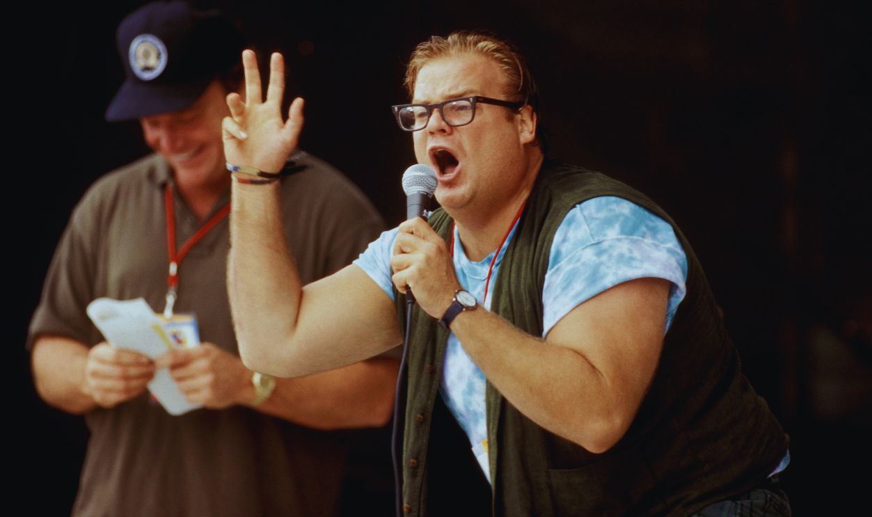 Gettyimages - 1216210685, Tom Arnold And Chris Farley On Stage At Woodstock 94. Comedians Tom Arnold and Chris Farley are shown talking to the crowd in between performance at Woodstock '94 on August 13, 1994. 