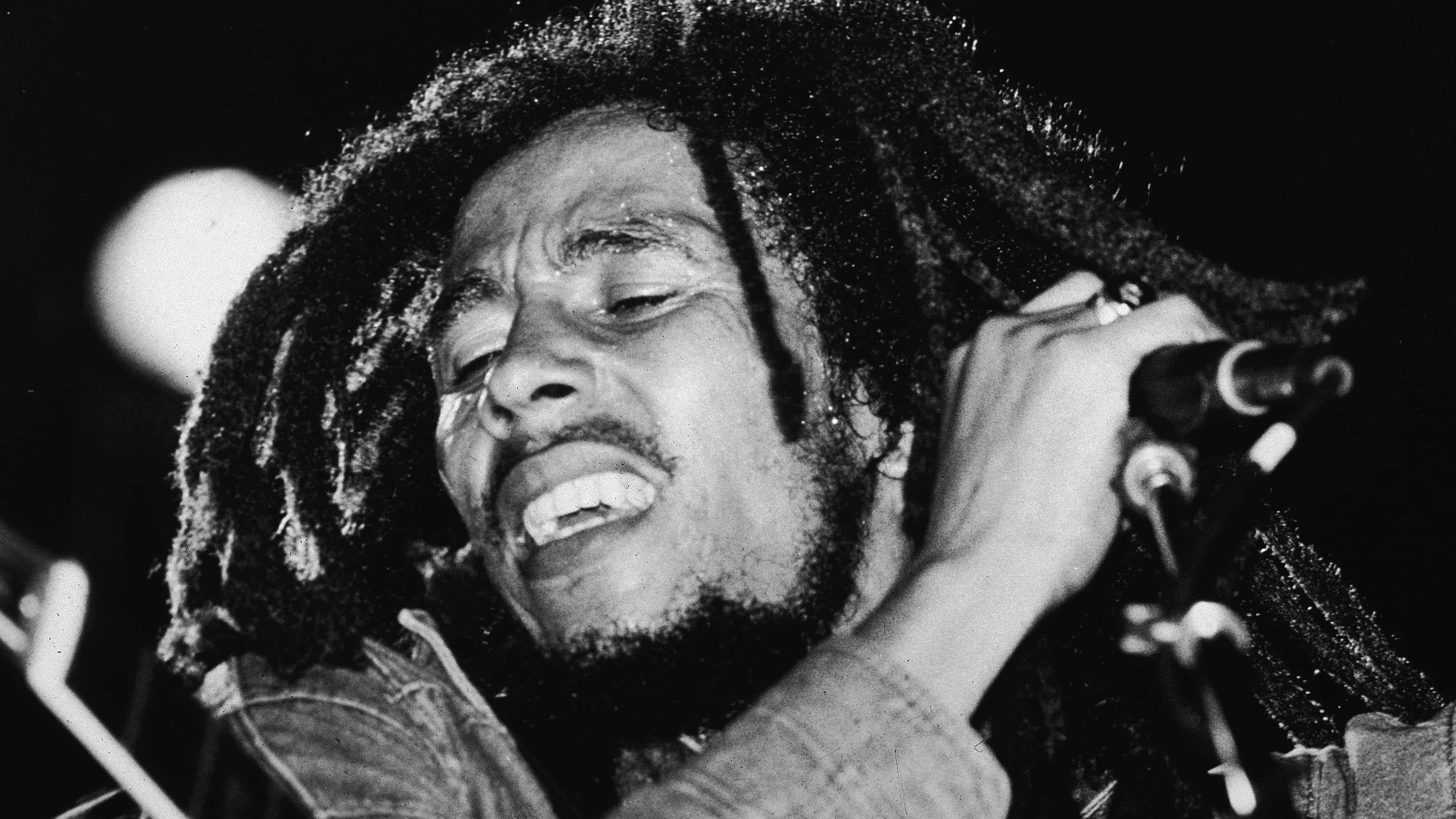 Jamaican reggae musician Bob Marley (1945 - 1981) performs on stage, a microphone in his hand, late 1970s.