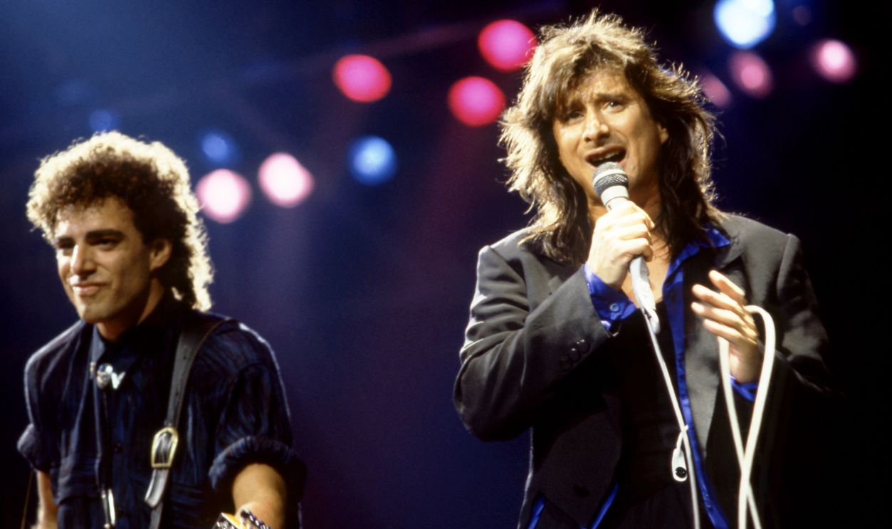 American rock guitarist Neal Schon and lead singer Steve Perry of the band Journey sing and play on stage during the 1986 Raised on Radio Tour on October 9, 1986 at the Joe Louis Arena in Detroit, Michigan.