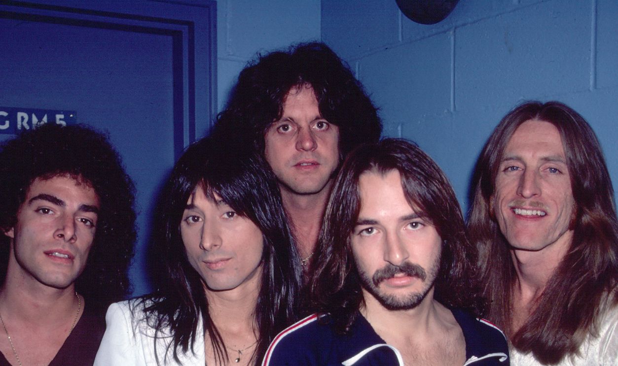 Portrait of members of American Rock group Journey as they pose backstage at Utica Memorial Auditorium (later known as the Adirondack Bank Center at the Utica Memorial Auditorium), Utica, New York, May 6, 1980. Pictured are, from left, Neal Schon, Steve Perry, Gregg Rolie, Steve Smith, and Ross Valory. 