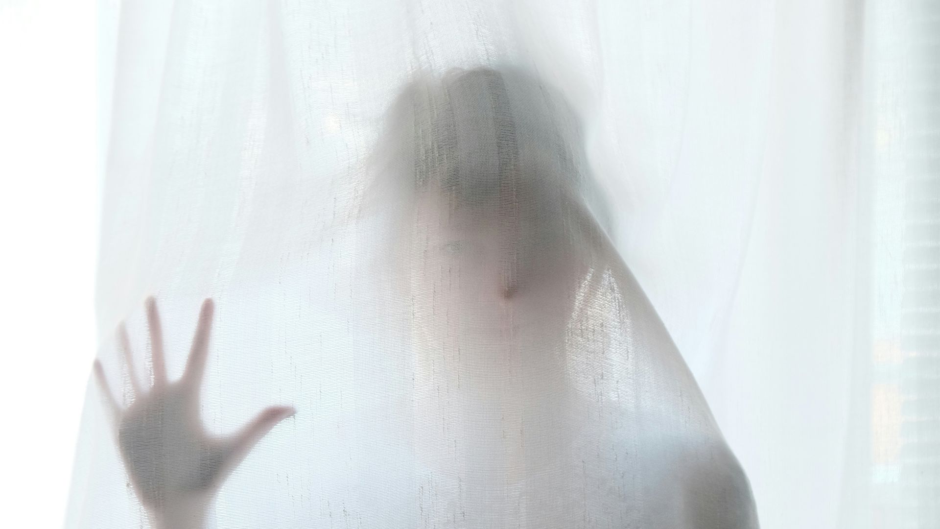 woman holding behind curtain
