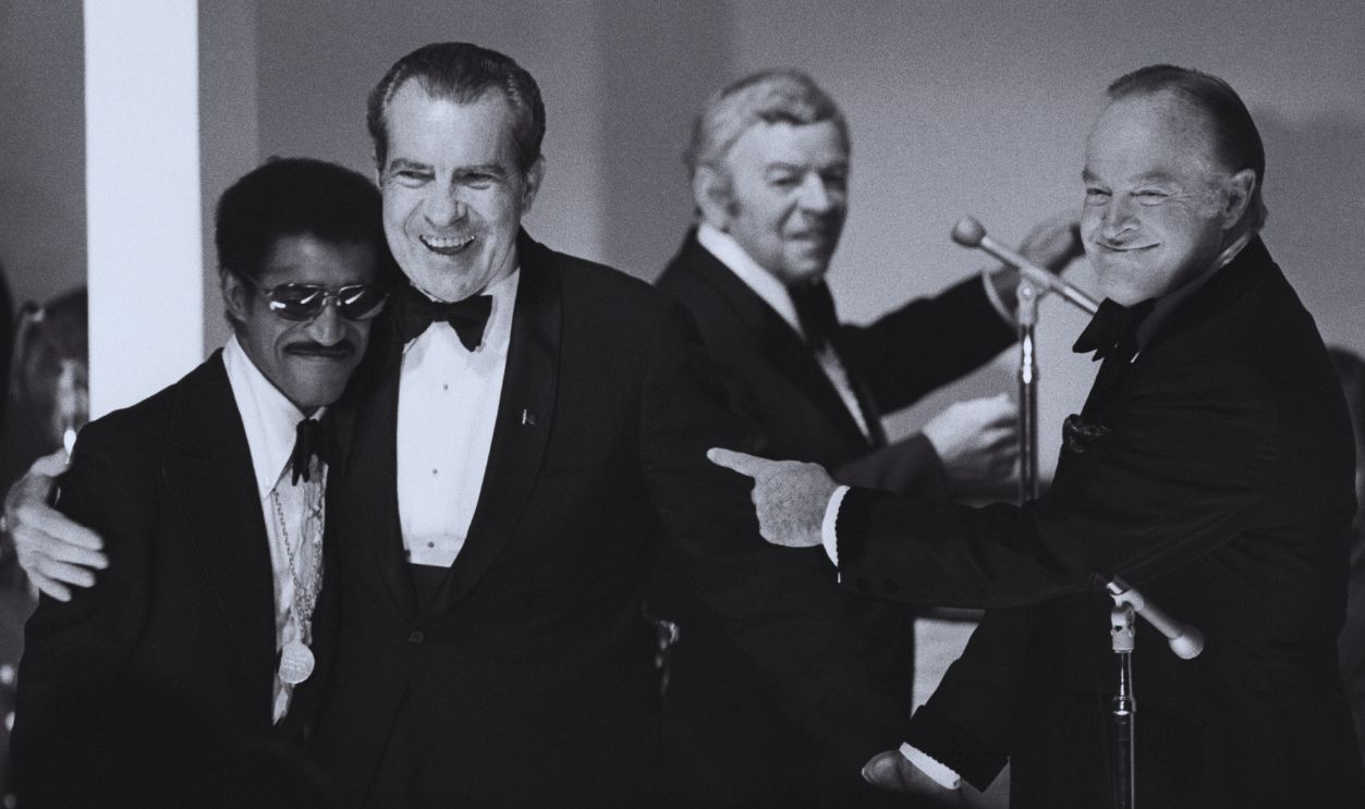 Gettyimages - 515575314, President Nixon Hugs Sammy Davis Jr. (Original Caption) WASHINGTON-5/25/73-: President Nixon hugs Sammy Davis Jr. as Bob Hope and bandleader Les Brown look on at the White House gala for returned prisoners of war 5/24. The entertainers put on a show for the POWs following dinner. 