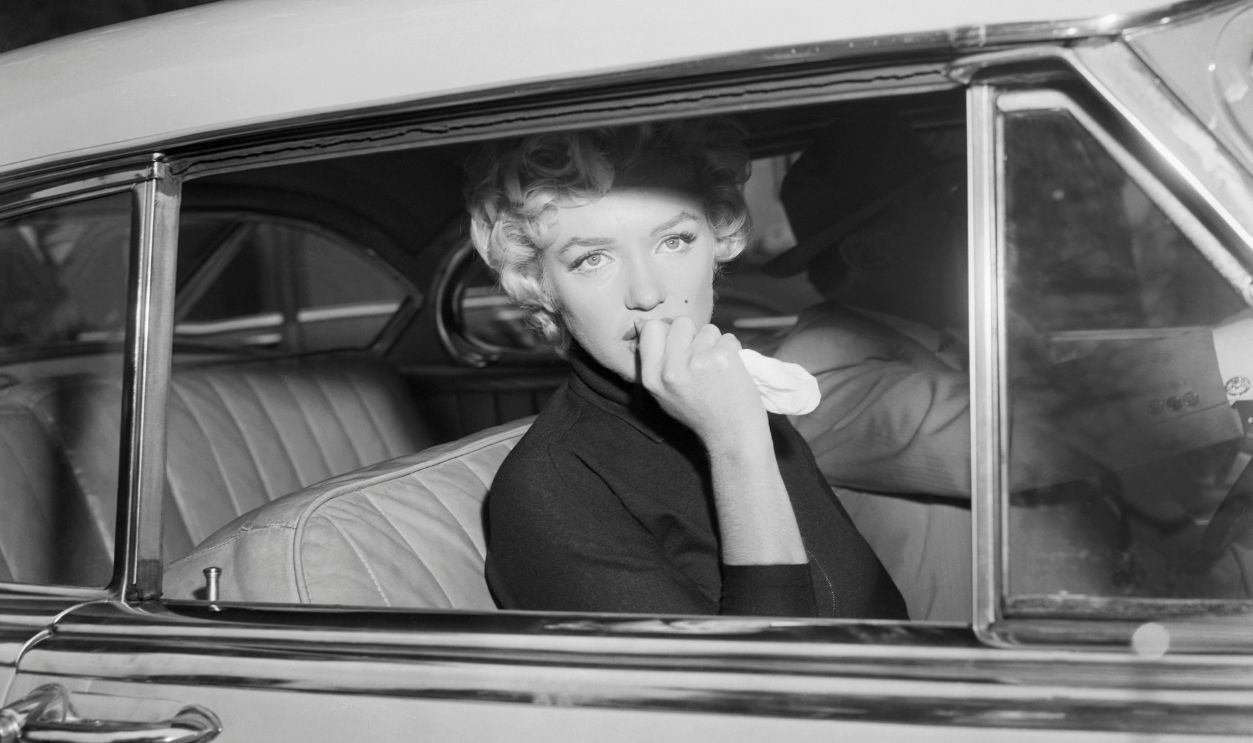 Marilyn Monroe leaves the home she briefly shared with Joe Di Maggio in a car driven by her attorney, Jerry Giesler. Monroe had just announced her intent to divorce Di Maggio on grounds of