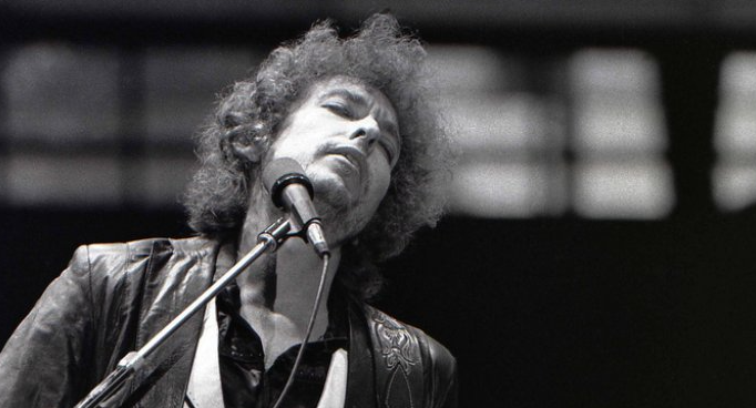 Grayscale Portrait Photo of Bob Dylan performing on stage in Rotterdam