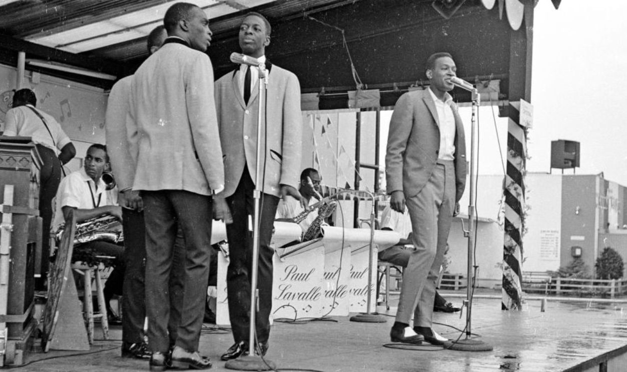 R&B singer Marvin Gaye performs onstage with a full band and doo-wop vocal group 