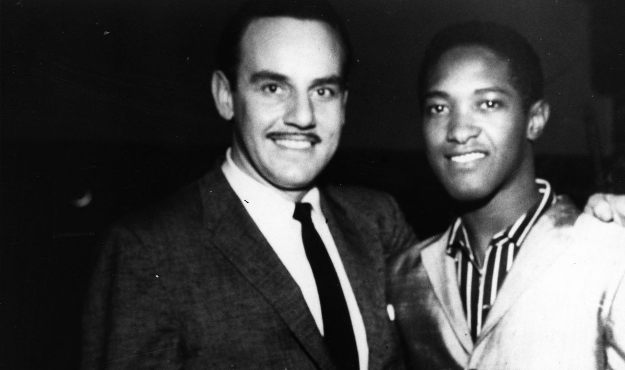  Band leader Johnny Otis poses for a portrait with singer Sam Cooke on the set of the first episode of 