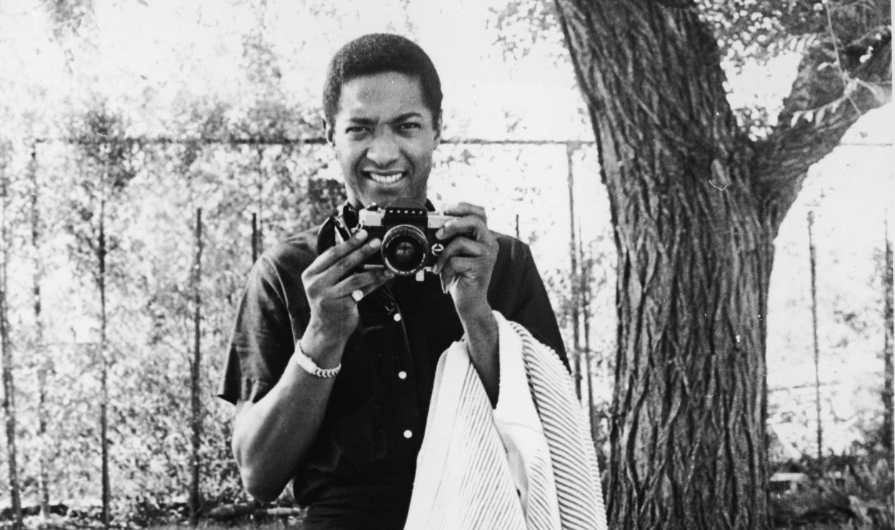 American soul singer Sam Cooke (1931 - 1964) gets ready to take a photograph while he holds a sweater over his left arm, early 1960s.
