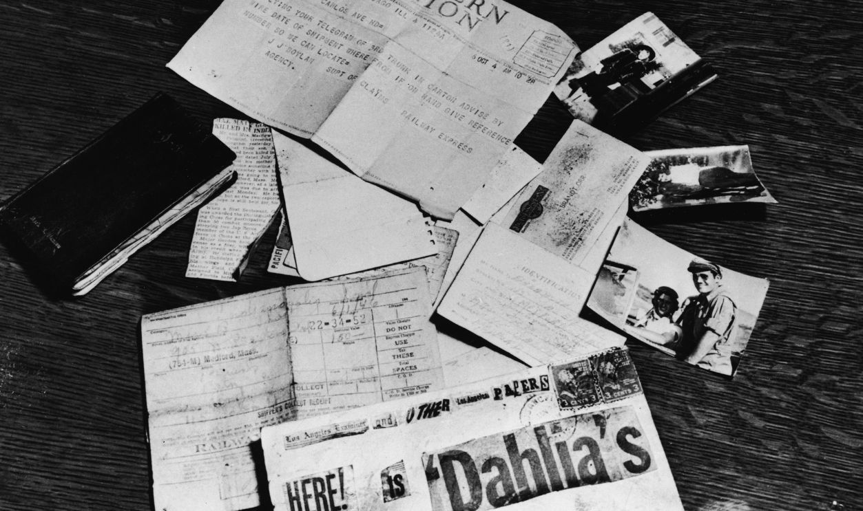 Gettyimages - 56717192, Black Dahlia Evidence Evidence concerning the murder of American aspiring actress and murder victim Elizabeth Short (1924 - 1947), known as the 'Black Dahlia,' is strown across a table at the Los Angeles District Attorney's office, Los Angeles, California, 1947. On the table is a black address book, a newspaper clipping about the death of Short's supposed fiance and American Amy Major Matthew M. Gordon Jr., Short's birth certificate, a business card, a threatening letter assembled from newspaper lettering, a baggage check from a Greyhound bus depot, a Western Union telegram, and several photographs of Short.