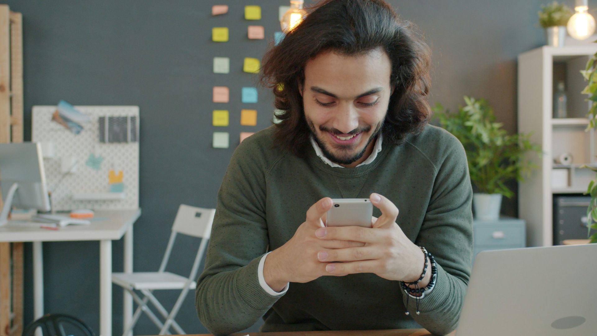 Man smiling while looking at his smartphone