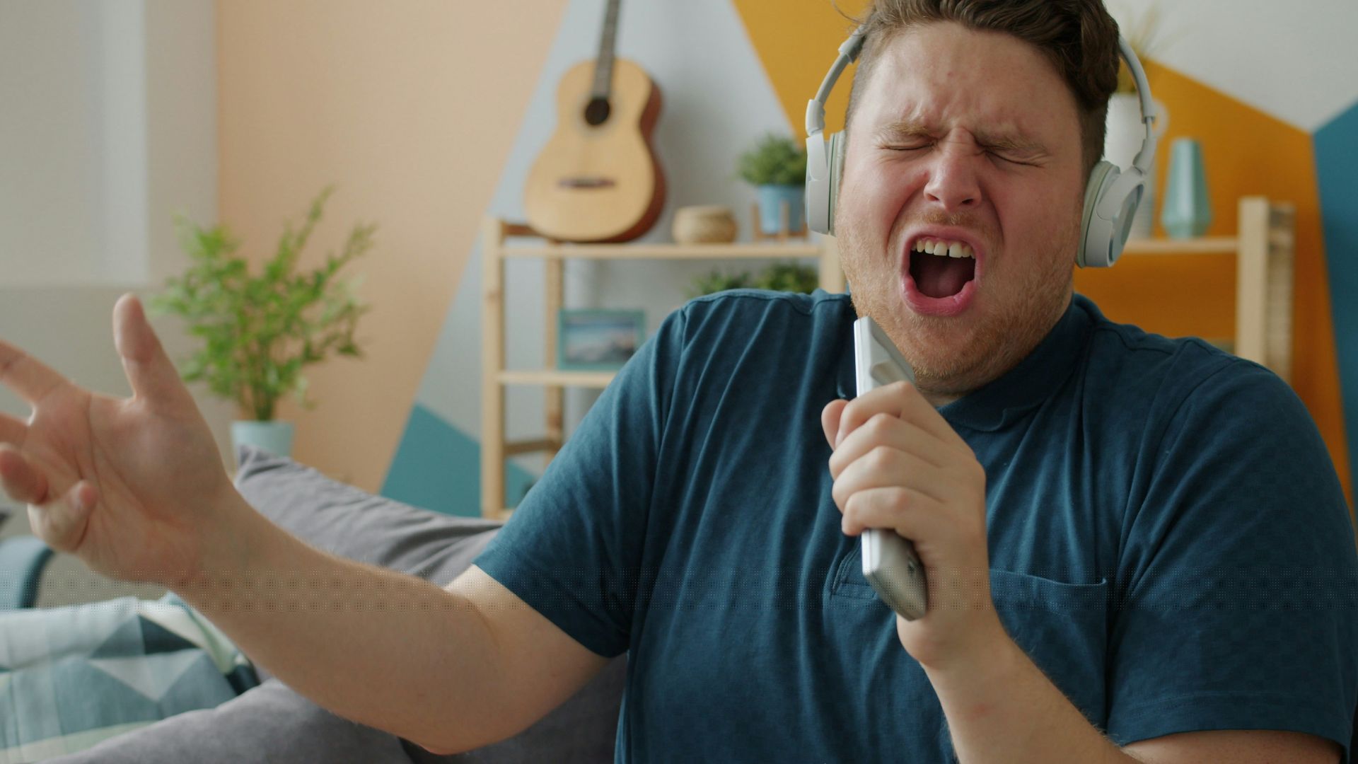 Man singing passionately while wearing headphones