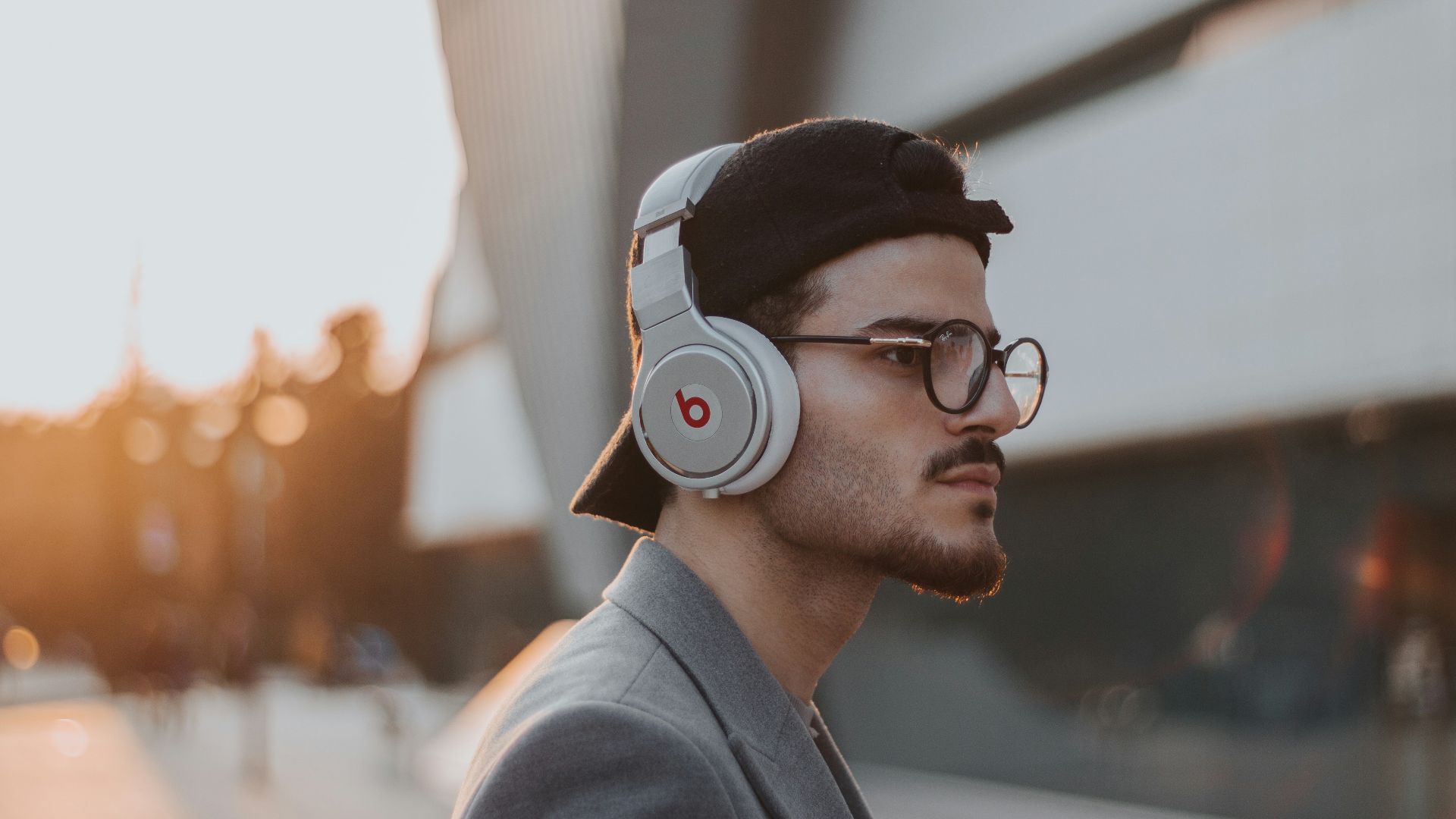 shallow focus photography of man wearing Beats wireless headphones