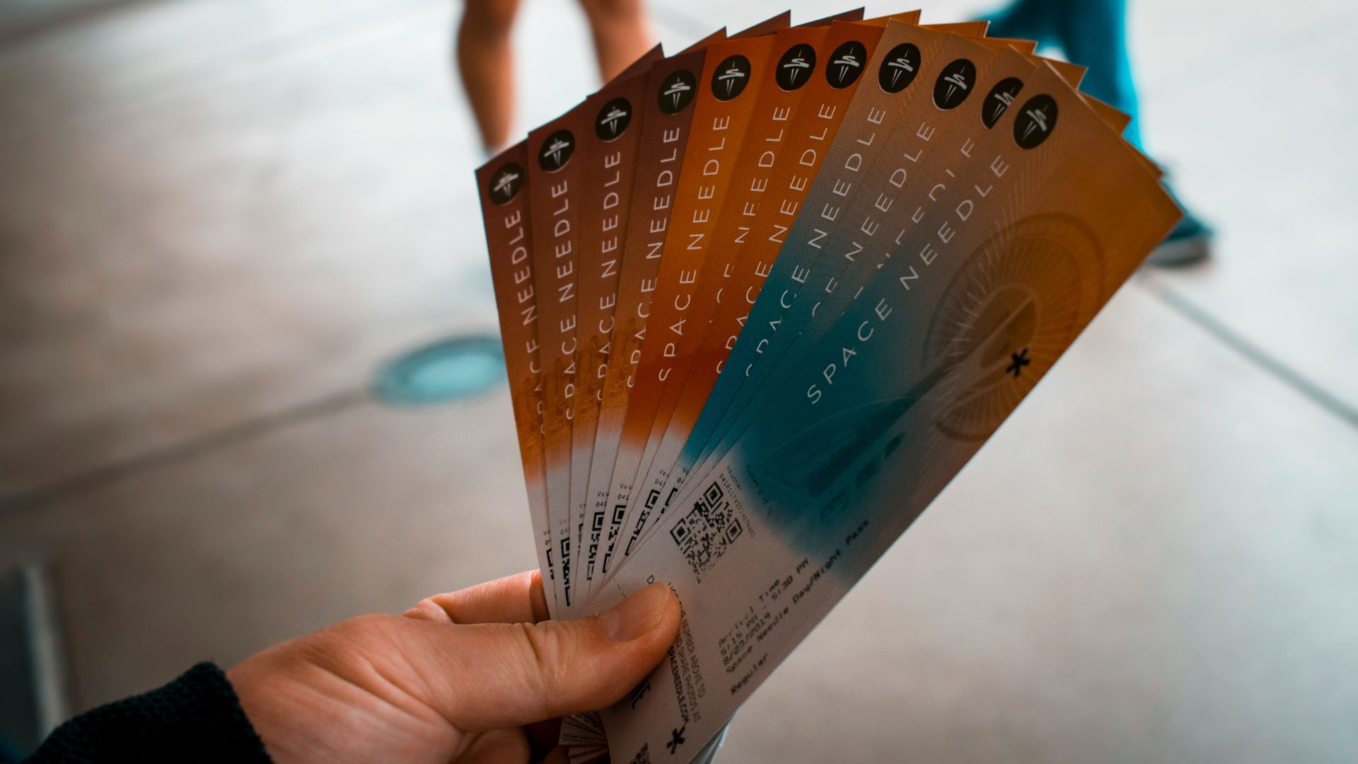 person holding brown, blue, and white tickets