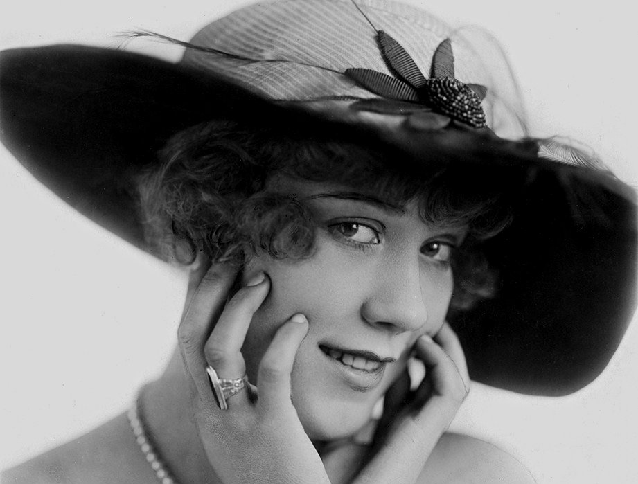 Portrait photograph of American actress and comedian Louise Fazenda wearing a hat