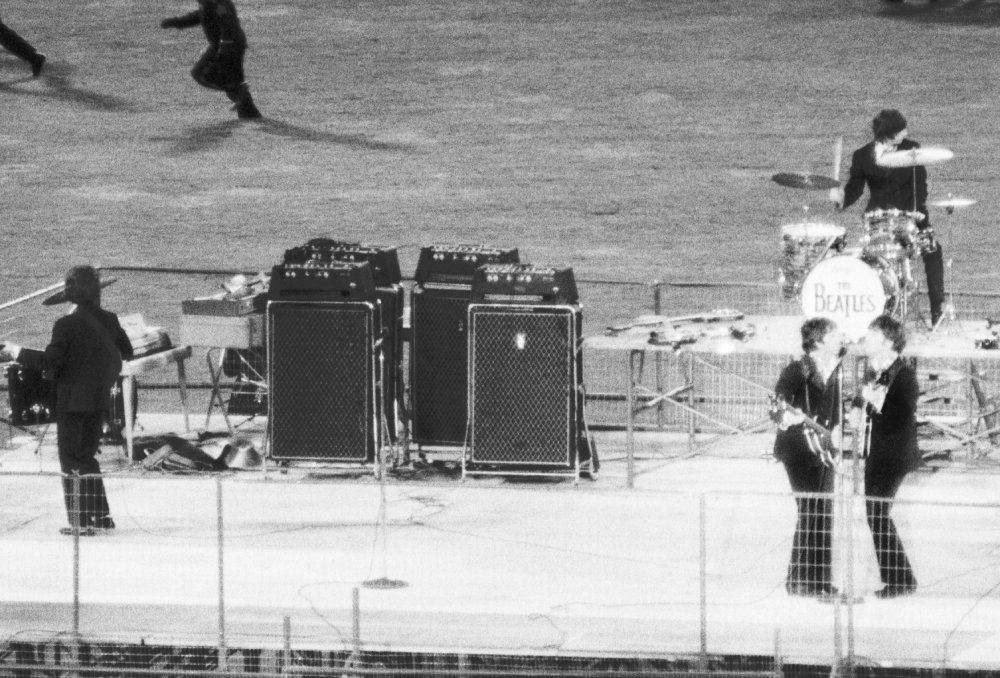 Policemen clear the field of enthusiastic fans as The Beatles perform