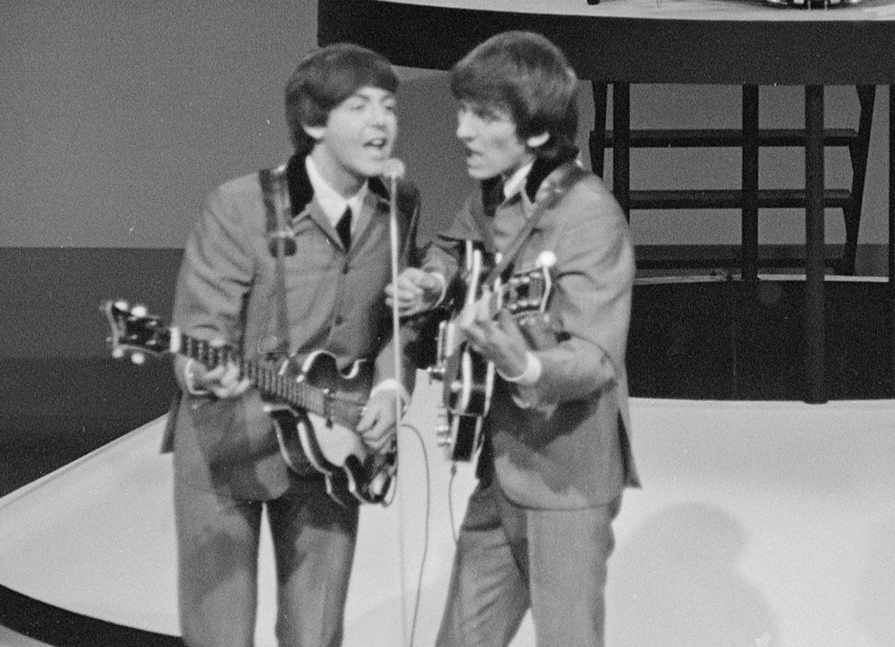 Grayscale Portrait Photo of Paul McCartney George Harrison Performing on Stage.