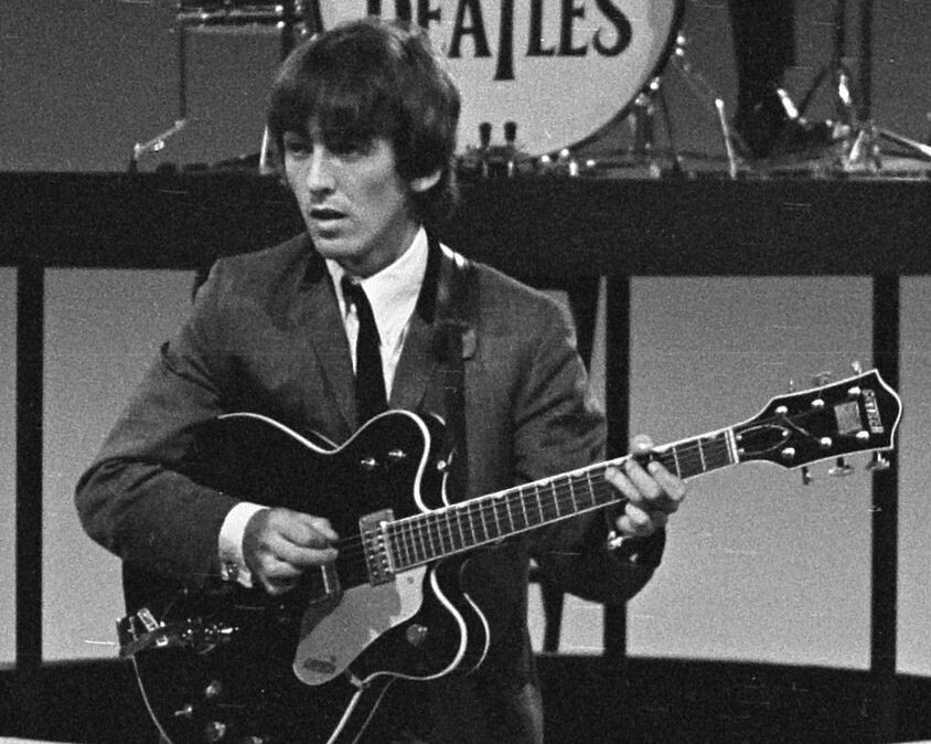Grayscale Portrait Photo of George Harrison Performing on stage